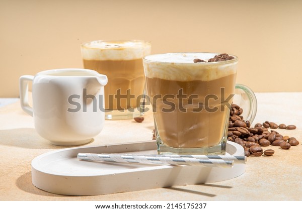 Cold dairy coffee drink with milk,\
whipped cream. Foamy frappe, latte, cappuccino, on a cream\
background, space for text. Summer cold coffee\
cocktail