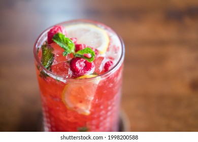 Cold drink black tea of raspberry lemonade with mint in glass. Selective focus
