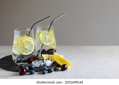 Cold drinks in small bottles. Cherries and lemon lemonade. Mojito cocktail. Summer iced refreshment drink. Summer cold mint cocktails with berries. Mason jar glass with cold drink. High quality photo