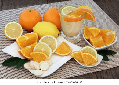 Reparación de la salud fría y gripal bebida con frutas anaranjadas y limón y comprimidos de vitamina c sobre el fondo de roble en bambú. 