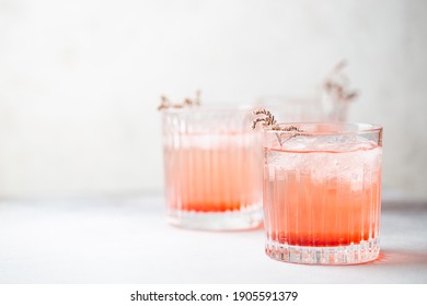 Cold Fresh Pink Lemonade Drink With Ice In A Glass On White Background, Selective Focus