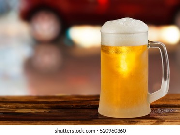 Cold Glass Mug Of Beer With Foam On The Background Of The Street