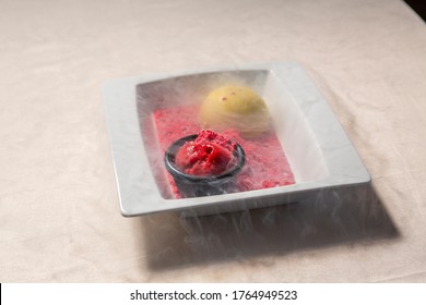 Cold ice cream dessert served with smoke on a plate