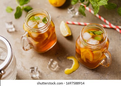 Cold iced tea with ice. Served in a jar with a paper straw.