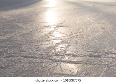 COLD ICY BACKGROUND AT SUN LIGHT, SCRATCHED SUFRACE FROM SKATES, ICE HOCKEY STADIUM