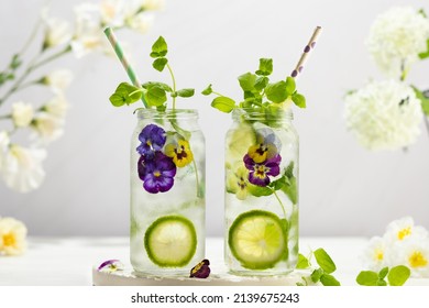 Cold Infused detox water with edible flowers,lime and mint leaves. Refreshing summer drink.