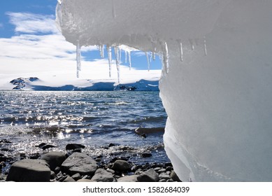 Cold landscape: snowy mountains, frozen water, ice stalactites in the seacoast. Antarctica