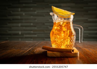 Cold lemon tea with ice cubes and lemon wedge, sits on the coaster with cinnamon stick - Powered by Shutterstock