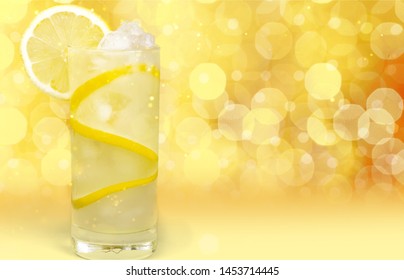 Cold Lemonade With Lemon Peel And Ice Pieces On Yellow Background