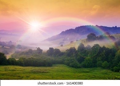 cold morning fog with red hot sunrise and rainbow in the mountains