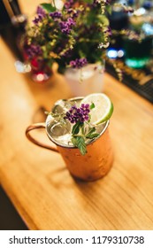 Cold Moscow Mule Cocktail In Copper Mug On Wooden Bar Desk At Restaurant Or Cafe From Top View.