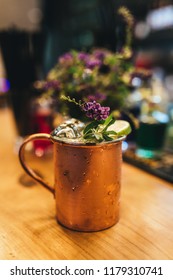 Cold Moscow Mule Cocktail In Copper Mug On Wooden Bar Desk At Restaurant Or Cafe From Top View.