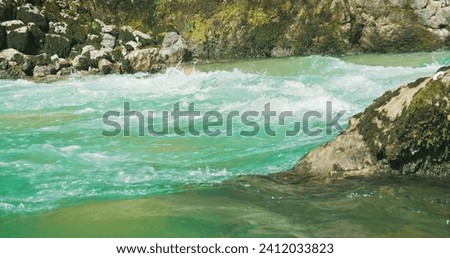 Cold mountain river with clear glacial water flows in a rocky gorge. Spring nature landscape in Alps.