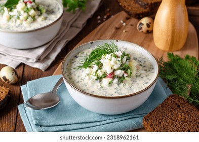 Cold Okroshka Soup with Eggs, Vegetables, Meat, Herbs and Kefir on a Wooden Rustic Background, Summer Soup