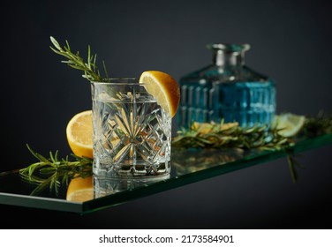 Cold Refreshing Drink With Lemon And Rosemary. Gin Tonic Cocktail In A Crystal Glass.