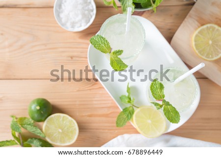 Cold refreshing summer lemonade mojito with fresh lemon and mint leaf. Top view.
