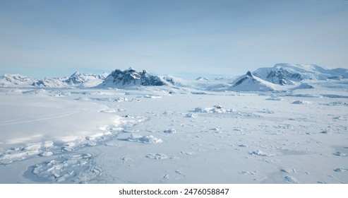 Cold South Pole winter landscape in sunny day. Snow covered frozen polar ocean, mountain range in background. Antarctica aerial majestic seascape drone view. Beauty of wild untouched nature. Travel - Powered by Shutterstock