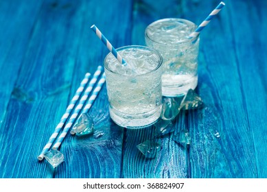 
Cold Sparkling Mineral Water With Ice In A Glass On A Blue Wooden Background