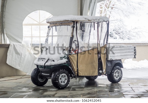 Cold Spring Harbor, USA - April 2 2018:\
Snow-covered golf cart in Cold Spring\
Harbor.
