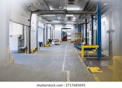 Cold storage warehouse interior with multiple loading docks, industrial refrigeration systems, and a forklift preparing for logistics operations