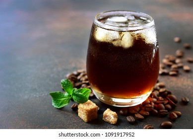 Cold summer cocktail with cola,whiskey and coffee liquor in a glass on a dark slate, stone or concrete background