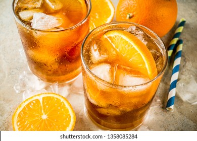 Cold summer cocktail, Iced coffee dink with orange slices, stone table copy space
