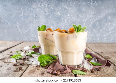 Cold Summer Coffee, Latte, Frappe, Frappuccino. Coffee Iced Cocktail Drink With Frozen Coffee Ice Cubes, Milk Or Non-dairy Milk And Mint Leaves. Wooden Background Copy Space