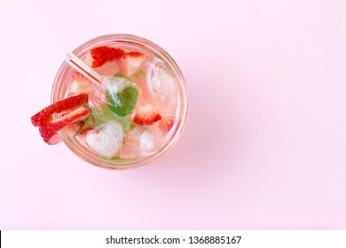 Cold summer drink with ice and strawberries on a pink background, top view - Shutterstock ID 1368885167