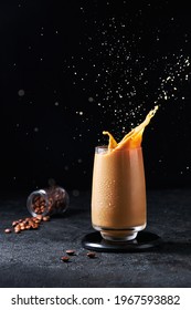 Cold Summer Drink. Iced Coffee With Splash In Tall Glass On Dark Background. Drinks In Motion