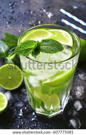 Cold summer drink mojito in a tall glass on a dark slate,stone or metal background.