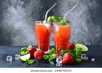 Cold summer strawberry cocktail with lime and basil in a  glasses on a dark slate, stone or concrete background.. - Powered by Shutterstock