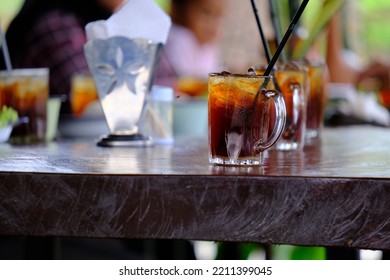 cold sweet tea lined up on a table with a wooden background - Shutterstock ID 2211399045