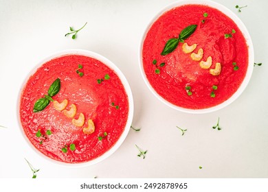 Cold Tomato Soup Gazpacho with basil, microgreens and celery in white cups on a light table. View from above. High quality photo - Powered by Shutterstock