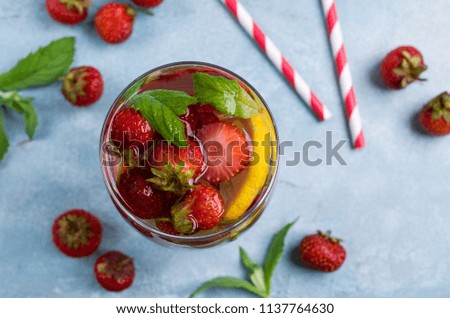 Cold transparent drink with fruit in the glass on the table. Selective focus.