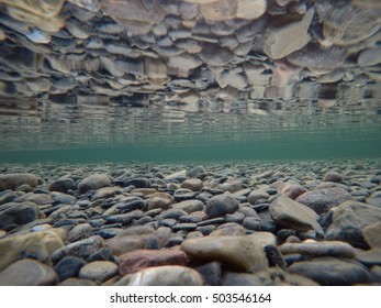 Cold Underwater River Bed With Perfect Reflection On Surface Tension