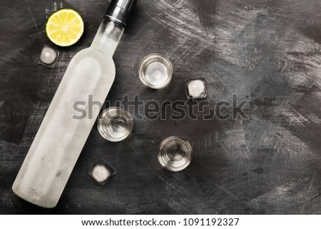 Cold vodka in shot glasses on a black background. Top view, copy space. Food background