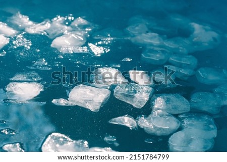 Cold water and ice cubes melting under the sun background. Global warming or climate change concept. Cold therapy, breathing techniques, yoga and meditation