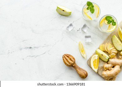 Cold Water With Ice, Ginger, Mint, Apple And Lemon Juice For Summer Healthy Drink On White Background Top View Mock-up