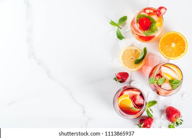 Cold white, pink and red sangria cocktails with fresh fruits, berries and mint.