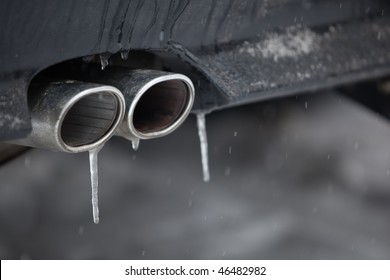Cold winter concept - detail of the exhaust pipe/tailpipe of a modern car with icicles