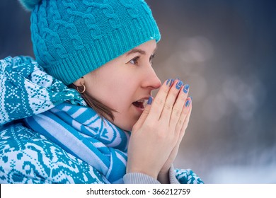  Cold Winter. Portrait Girl In A Blue Cap And Jacket Warms Her Hands