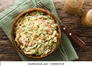 Coleslaw Made Of Freshly Shredded White Cabbage And Grated Carrot With Homemade Mayonnaise-based Salad Dressing In Wooden Bowl, Photographed Overhead (Selective Focus, Focus On The Salad)
