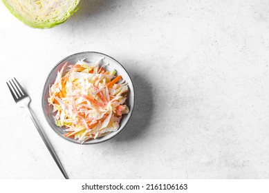 Coleslaw Salad. Organic Cabbage ans Carrots salad - healthy diet, detox, vegan, vegetarian, fermented vegetable  salad on white table, copy space