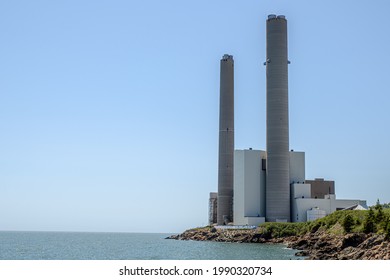 The Coleson Cove Generating Station In Saint John, NB, Canada, A Fossil Fuel Generation Station That Burns Fuel Oil. Blue Sky Above Ocean To The Left.