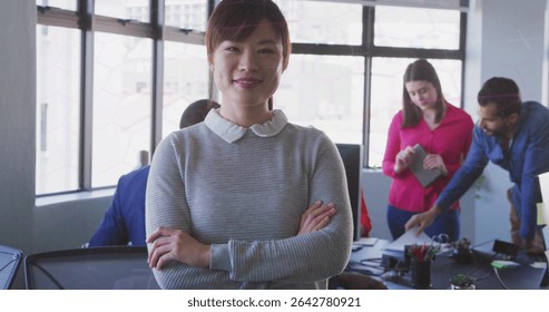 Collaborating five professionals reviewing documents in bright office, with laptop and monitor. Business, teamwork, modern, workspace, productivity, corporate, communication