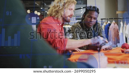 Collaborating manager and associate analyzing orange fabric on table at store, with digital tablet. Collaboration, teamwork, retail, fashion, analysis, modern, innovation