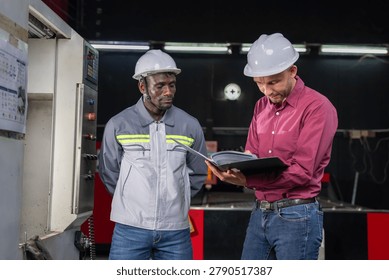 Collaboration between engineers and technicians in industrial setting factory floor documentation review professional environment close-up perspective