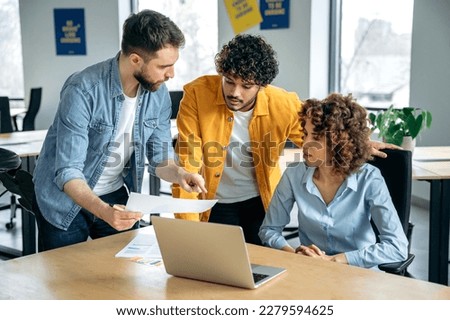 Collaboration concept. Successful people of different nationalities, creative business team, working together on a project in a modern office, watching presentation, discussing ideas, brainstorming