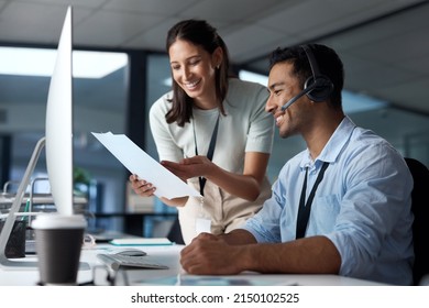 Collaboration Gets Those Queues Cleared. Shot Of A Young Man And Woman Reading A Document While Working In A Call Centre.