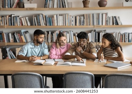 Collaboration in learning. Busy multiethnic young people college university students team study scientific literature at campus library prepare for test exam work together on group research with books